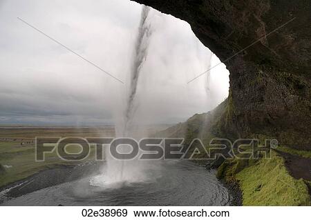 Landscape of farmland from behind water falling into a pool from a cliff View Large Photo Image Stock Photo - Landscape of farmland from behind water falling into a pool from a cliff. Fotosearch