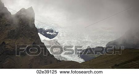 Landscape of Skaftafellsjokull glacier, framed by rugged misty mountains View Large Photo Image Stock Photography - Landscape of Skaftafellsjokull glacier, framed by rugged misty mountains. Fotosearch