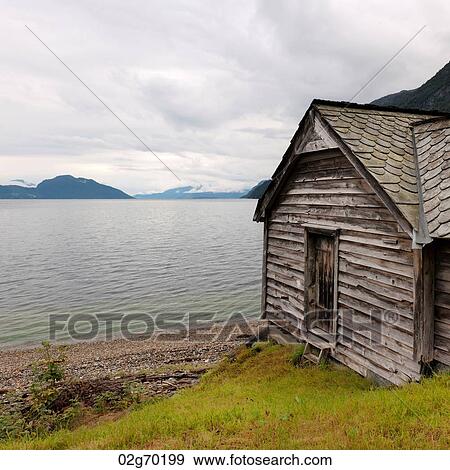 Stock Photo - Log cabin at the riverside, Hardangervidda, Hardanger, Norway. Fotosearch