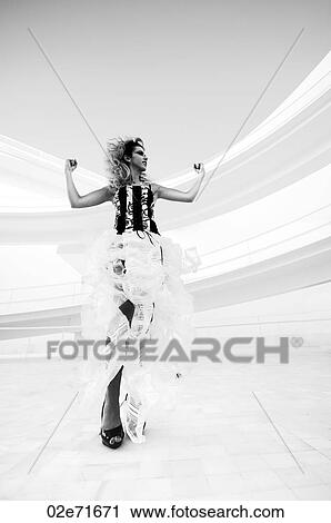 Stock Image - Low angle photograph of stylish woman in a modern abstract interior. Fotosearch