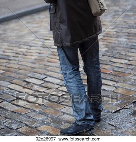 Stock Photo - Lower portion of a man standing on a street in Manhattan, New York City, U. S. A.. Fotosearch
