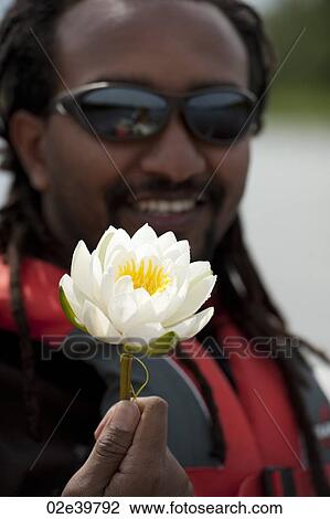 Man holding a white water lily View Large Photo Image Stock Image - Man holding a white water lily. Fotosearch