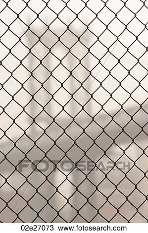 Stock Image - Manhattan Bridge through a chain link fence in Manhattan, New York City, U. S. A.. Fotosearch