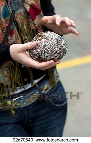 Stock Image - Mid section view of a woman holding a craft product in Plaza Regocijo, Cuzco, Peru. Fotosearch