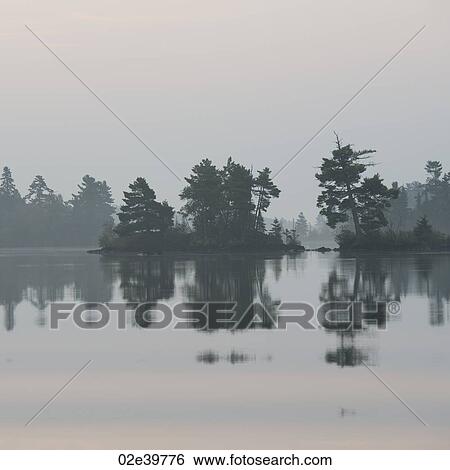 Stock Photograph - Misty sky over Lake of the Woods, Ontario. Fotosearch