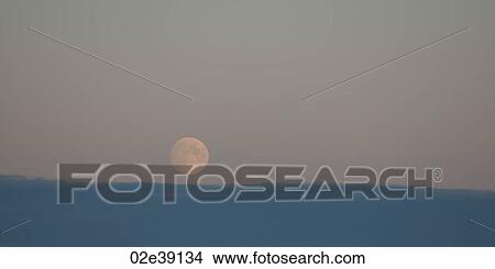 Moon rising over the cloudy horizon View Large Photo Image Picture - Moon rising over the cloudy horizon. Fotosearch