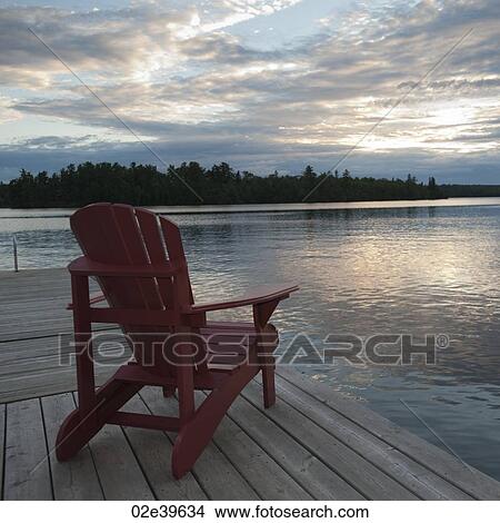 Picture - Muskoka chair on dock at Lake of the Woods, Ontario. Fotosearch