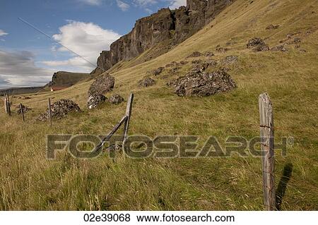 Pastureland on scree mountainside with rock outcrop and barbed wire fence View Large Photo Image Stock Photo - Pastureland on scree mountainside with rock outcrop and barbed wire fence . Fotosearch