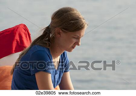 Stock Photography - Profile of teenage girl looking downwards at Lake of the Woods, Ontario. Fotosearch