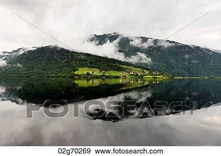 Reflection of mountain with clouds in the lake, Granvinsvatnet, Granvin, Hordaland County, Norway View Large Photo Image Stock Photo - Reflection of mountain with clouds in the lake, Granvinsvatnet, Granvin, Hordaland County, Norway. Fotosearch