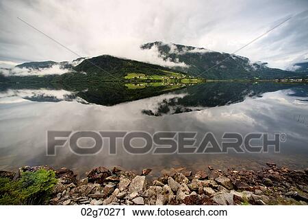 Reflection of mountains with clouds in the lake, Granvinsvatnet, Granvin, Hordaland County, Norway View Large Photo Image Stock Image - Reflection of mountains with clouds in the lake, Granvinsvatnet, Granvin, Hordaland County, Norway. Fotosearch