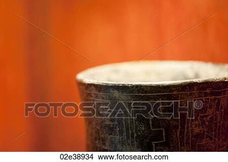 rim of inscribed brown exterior and white interior vase against vibrant orange background View Large Photo Image Picture - rim of inscribed brown exterior and white interior vase against vibrant orange background. Fotosearch