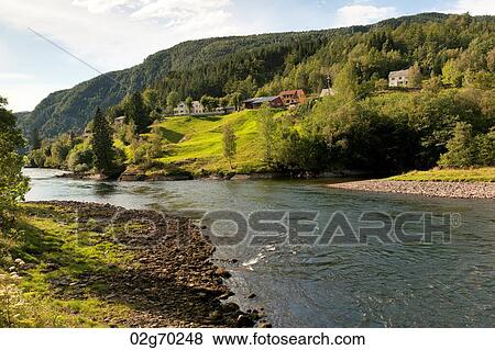 River flowing with village in the background, Norway View Large Photo Image Stock Photo - River flowing with village in the background, Norway. Fotosearch