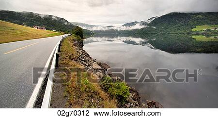 Stock Image - Road passing through mountains, Granvinsvatnet, Granvin, Hordaland County, Norway. Fotosearch
