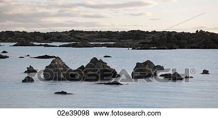 Rocks rising from the water along shore of lagoon View Large Photo Image Stock Photo - Rocks rising from the water along shore of lagoon. Fotosearch