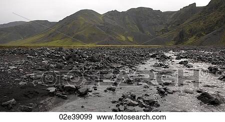 Rocky river bed below rugged mountains View Large Photo Image Stock Photo - Rocky river bed below rugged mountains. Fotosearch