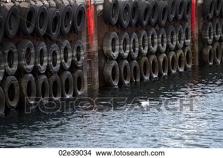 Rubber tire lined wharf with fluourescent access ladders View Large Photo Image Picture - Rubber tire lined wharf with fluourescent access ladders. Fotosearch