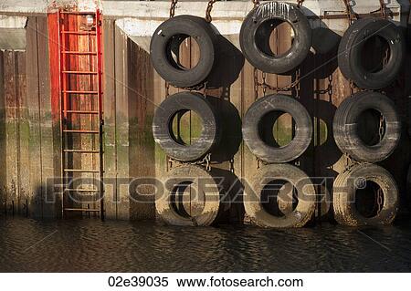 Rubber tire lined wharf with fluourescent access ladders View Large Photo Image Stock Photography - Rubber tire lined wharf with fluourescent access ladders. Fotosearch