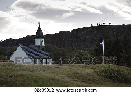 Stock Image - Rural church and flagpole next to hillside. Fotosearch