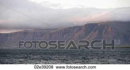 Seascape, ocean and cloud topped cliffs in evening View Large Photo Image Stock Photo - Seascape, ocean and cloud topped cliffs in evening. Fotosearch