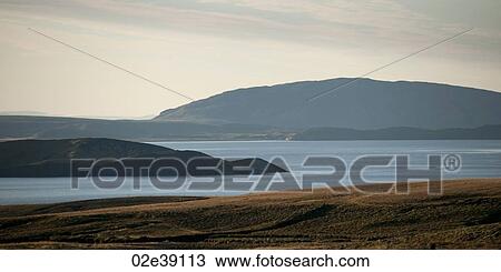 Stock Image - Seascape, ocean and mountains on a serene day. Fotosearch