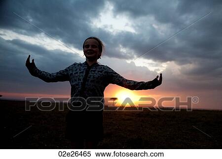 Stock Photography - Silhouette of girl against Kenya sky at sunset. Fotosearch