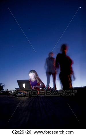 Stock Image - Silhouette of people gainst Kenya sky at sunset. Fotosearch