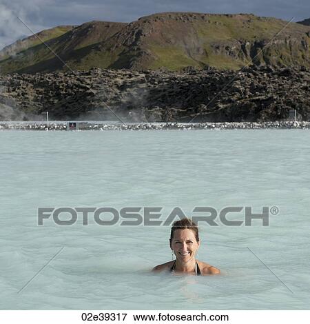 Smiling woman in bathing suit submerged in geothermal mineral pool View Large Photo Image Stock Photo - Smiling woman in bathing suit submerged in geothermal mineral pool. Fotosearch
