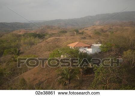 Stock Image - Solitary white house with an orange roof in the hilltops of Costa Rica. Fotosearch