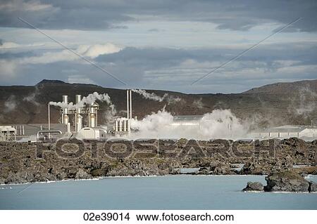 Steam rising from a geothermal power station above a rocky lake coastline View Large Photo Image Picture - Steam rising from a geothermal power station above a rocky lake coastline. Fotosearch