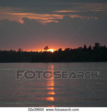 Stock Image - Sunset horizon over Lake of the Woods, Ontario. Fotosearch
