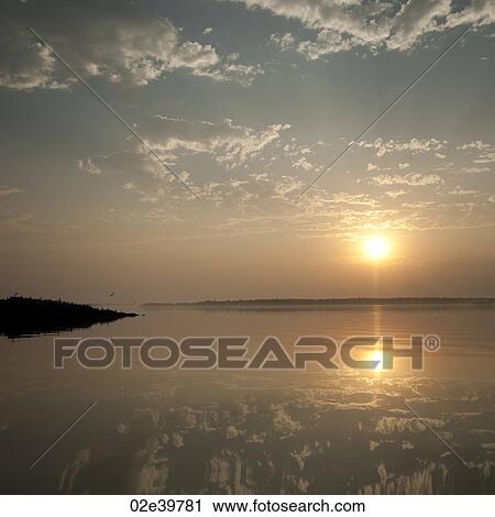 Stock Image - Sunset over the water at Lake of the Woods, Ontario. Fotosearch