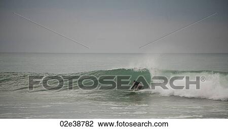 Surfer along Mal Pais coastline in San Jose Costa Rica View Large Photo Image Stock Image - Surfer along Mal Pais coastline in San Jose Costa Rica. Fotosearch