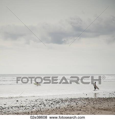 Surfer along ocean seashore in Costa Rica View Large Photo Image Stock Photo - Surfer along ocean seashore in Costa Rica. Fotosearch