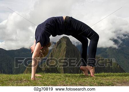 Teenage girl doing wheel pose with valley in the background, The Lost City of The Incas, Machu Picchu, Cusco Region, Peru View Large Photo Image Stock Photo - Teenage girl doing wheel pose with valley in the background, The Lost City of The Incas, Machu Picchu, Cusco Region, Peru. Fotosearch