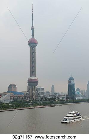 Tourboat with the Oriental Pearl Tower in the background, Pudong, Shanghai, China View Large Photo Image Stock Photo - Tourboat with the Oriental Pearl Tower in the background, Pudong, Shanghai, China. Fotosearch