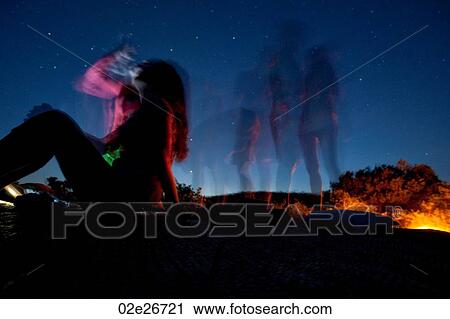 Stock Image - Tourists around a campfire in Kenya Africa. Fotosearch