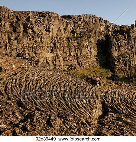 Volcanic rock flow waves and layered cliffs View Large Photo Image Stock Photo - Volcanic rock flow waves and layered cliffs. Fotosearch