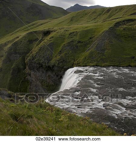 Waterfall cascade in verdant grassland View Large Photo Image Stock Image - Waterfall cascade in verdant grassland. Fotosearch