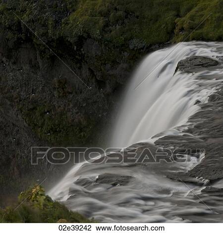 Waterfall cascade in verdant grassland View Large Photo Image Stock Image - Waterfall cascade in verdant grassland. Fotosearch