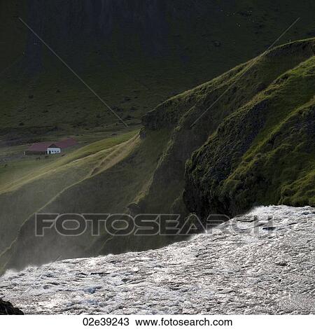 Stock Image - Waterfall cascade in verdant grassland. Fotosearch