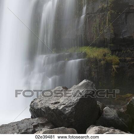 Stock Image - Waterfall onto boulders. Fotosearch