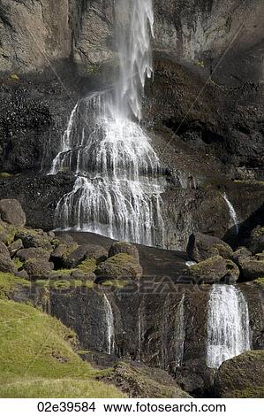 Waterfall over rocky cliffs in Iceland View Large Photo Image Picture - Waterfall over rocky cliffs in Iceland. Fotosearch