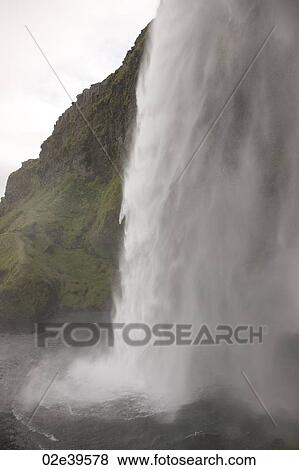 Waterfall over rocky cliffs in Iceland View Large Photo Image Stock Photo - Waterfall over rocky cliffs in Iceland. Fotosearch