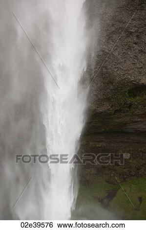 Waterfall over rocky cliffs in Iceland View Large Photo Image Stock Photograph - Waterfall over rocky cliffs in Iceland. Fotosearch