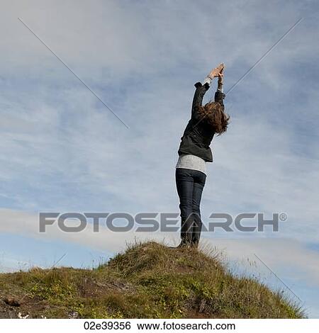 Woman having standing stretch on hilltop View Large Photo Image Stock Photograph - Woman having standing stretch on hilltop. Fotosearch