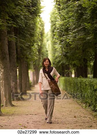 Woman on path between trees in Paris France View Large Photo Image Stock Photo - Woman on path between trees in Paris France. Fotosearch