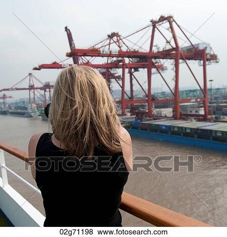 Woman taking picture of commercial dock, Yangtze River, Shanghai, China View Large Photo Image Stock Photo - Woman taking picture of commercial dock, Yangtze River, Shanghai, China. Fotosearch