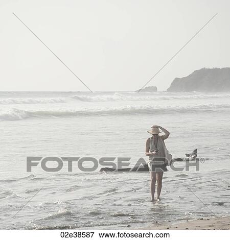 Stock Photo - Woman walking along the Seashore in Costa Rica. Fotosearch