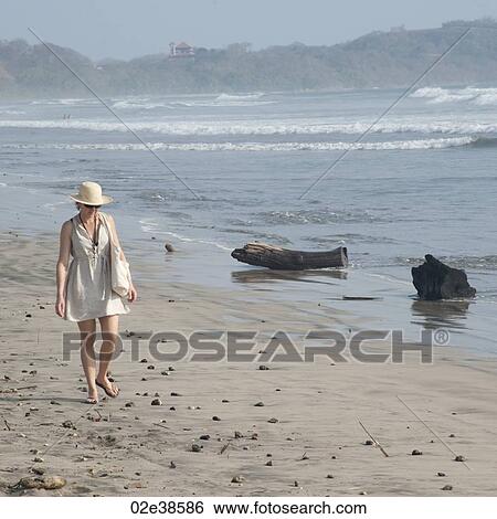 Stock Photograph - Woman walking along the Seashore in Costa Rica. Fotosearch